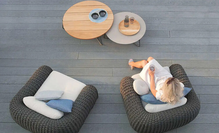 Woman sitting outside on a verandah made of Millboard composite decking.